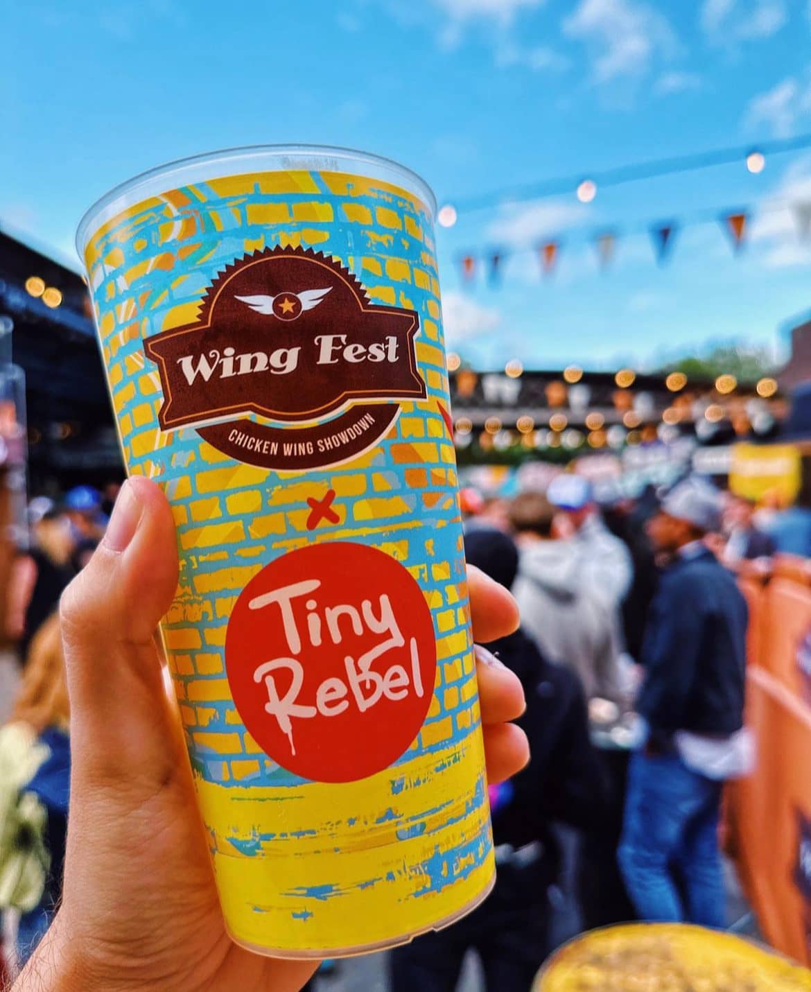 Branded printed cups held by guests at an event